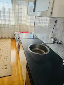 a bathroom with a black counter with a sink at Linden Alley Retreat Sarajevo with free parking in Sarajevo