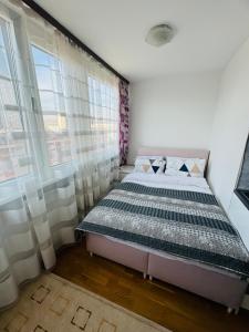 a bedroom with a bed and a large window at Linden Alley Retreat Sarajevo with free parking in Sarajevo