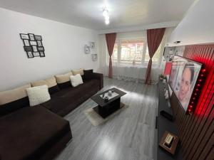 sala de estar con sofá y TV en AKY Residence, en Slănic-Moldova