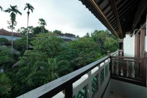 a balcony with a view of trees and bushes at New Mumbul Ubud in Ubud