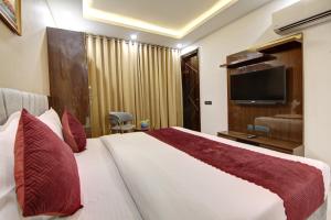 a hotel room with a bed and a flat screen tv at Limewood Stay - Millennium Huda city center in Gurgaon
