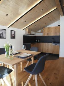 eine Küche und ein Esszimmer mit einem Holztisch und Stühlen in der Unterkunft Ferienwohnungen Alpinum in Krün