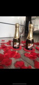 twee flessen en glazen op een tafel met rode bloemen bij Maremma10 in Turijn