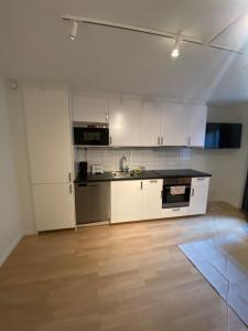 a kitchen with white cabinets and a black counter top at Norhemsgatsn 23 in Gothenburg