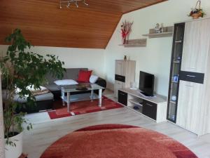 a living room with a couch and a tv at Ferienwohnung Unger in Stützengrün