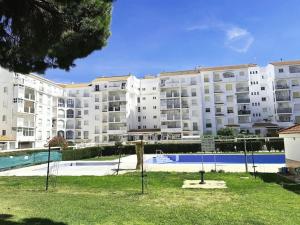 een groot appartementencomplex met een speeltuin ervoor bij LIFE APARTMENTS EL PORTIL in El Portil