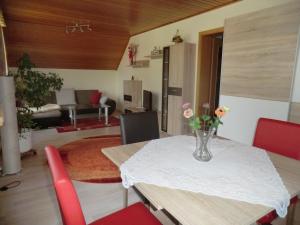 a dining room table with a vase of flowers on it at Ferienwohnung Unger in Stützengrün