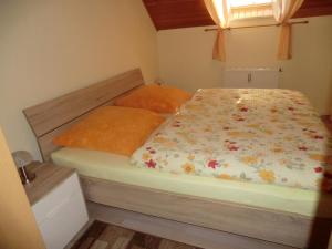1 Schlafzimmer mit einem Bett mit Blumenbettdecke in der Unterkunft Ferienwohnung Unger in Stützengrün