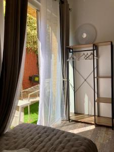 a bedroom with a bed and a large window at Hôtel Le Gambetta in Vias