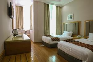 een hotelkamer met 2 bedden en een televisie bij New Day Hotel in Addis Ababa