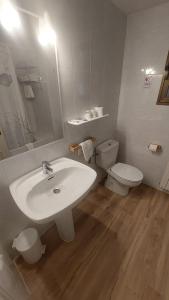 a bathroom with a white sink and a toilet at Hostal Rural Sositana in Castejón de Sos