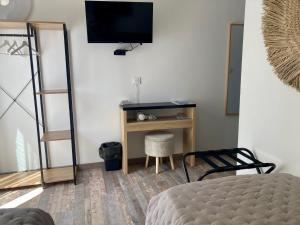 a bedroom with a bed and a television on a wall at Hôtel Le Gambetta in Vias
