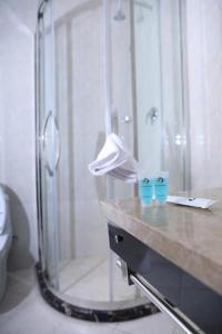 La salle de bains est pourvue d'une douche et d'un comptoir avec deux tasses bleues. dans l'établissement New Day Hotel, à Addis-Abeba