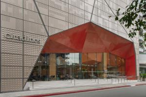 a large glass building with a red at Citadines Benavidez Makati in Manila