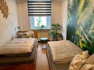 a bedroom with two beds and a window with a window blindiosyn at Ferienwohnungen Familie Schmidt in Gera