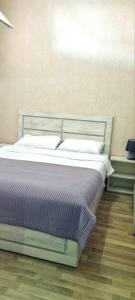 a bed in a room next to a wall at Kate's cozy apartment in Kutaisi