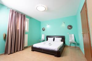 パリウリにあるStone Villaの青い壁のベッドルーム1室、ベッド1台(白いシーツ付)