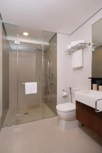 e bagno con doccia, servizi igienici e lavandino. di Citadines Benavidez Makati a Manila