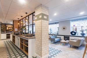 a living room with a brick pillar in the middle at Garner Hotel Cologne - Engelbertz by IHG in Cologne +66 photos