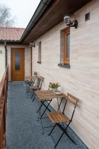 a row of tables and chairs next to a building at Penzion V Koutě in Zlechov