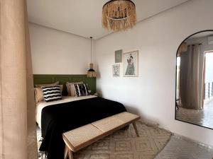 マラケシュにあるRIAD LE M neuf et contemporainのベッドルーム(ベッド1台、ベンチ付)