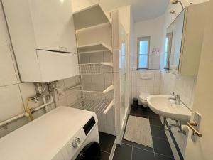 biała łazienka z umywalką i pralką w obiekcie modern Apartment in Osnabrueck w mieście Osnabrück