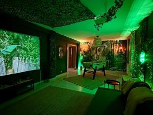 uma sala de estar com iluminação verde e um sofá e uma mesa em Jungle House - Maison em Hurtigheim