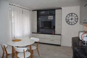 a kitchen with a white table and chairs and a clock at Sea apartment / Апартамент до морето in Varna City