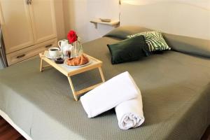 Una cama con una mesa con una bandeja de comida. en Nuovo Hotel Giardini, en Bra