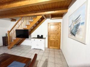 ein Wohnzimmer mit einer Treppe und einem TV in der Unterkunft Nordseeferien Nessmersiel in Neßmersiel
