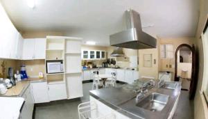 a kitchen with white cabinets and a stove top oven at A Famosa CASA BRANCA Da Barra! Suíte 3 clássica! in Rio de Janeiro