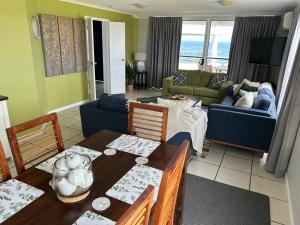 a living room with a table and a couch at Ocean Front Apartment at the Bargara Blue Resort in Bargara