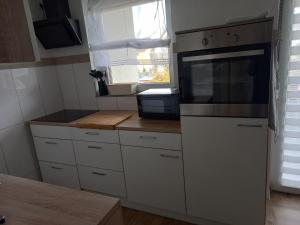 a kitchen with white cabinets and a microwave at Ferienwohnung OLA in Homburg