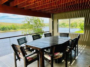 a table and chairs on a porch with a view of the water at Malgas 168 - Kom Binne Home in Malgas