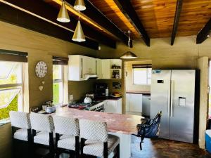 a kitchen with a counter with chairs and a refrigerator at Malgas 168 - Kom Binne Home in Malgas +23 photos