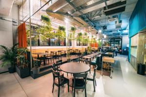 un ristorante con tavoli, sedie e piante di The Social Hub Bologna a Bologna