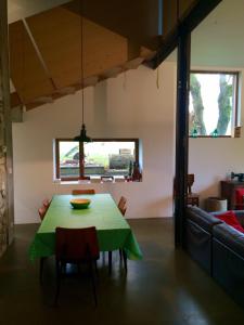 a dining room with a green table and chairs at gerestaureerde hoeve met zicht in Durbuy