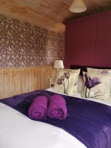 - un lit avec des couvertures violettes dans l'établissement Shepherd's Hut at Cefn Tilla Court, à Usk