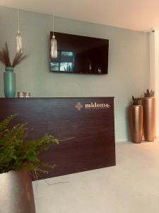 a wooden counter in a room with potted plants at MiDoma, Self Check-In Hotel, Hannover Messe in Hannover