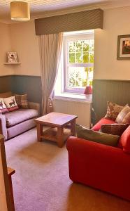 a living room with a couch and a table at Strathlachlan Lodge, Luxury Country House with Hot tub & Sauna in Strachur