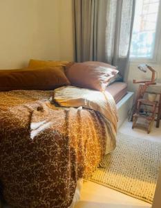een slaapkamer met een bed met een deken en een raam bij c’est la vie… à Marseille in Marseille