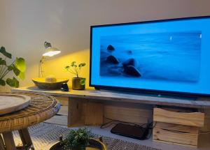 een grote flatscreen-tv zittend op een houten tafel bij c’est la vie… à Marseille in Marseille