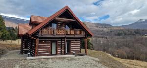 a log cabin on a hill in the mountains at Apartamenty komu gloria in Wetlina