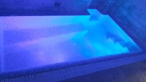 a large swimming pool with blue lights in it at Trulli e Puglia Luxury Suite in Alberobello