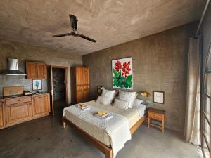 a bedroom with a bed and a ceiling fan at Les Terrasses Suites in Calheta