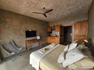 - une chambre avec un lit et une télévision à écran plat dans l'établissement Les Terrasses Suites, à Calheta