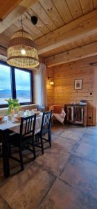 a dining room with a table and chairs in a cabin at Apartamenty komu gloria in Wetlina