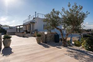 a house with a tree and a wooden walkway at Villa Giulia in Alcamo