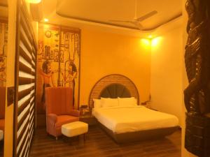 a bedroom with a bed and a chair at Samardha Jungle Resort in Bhopal