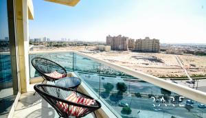 a balcony with two chairs and a view of a city at RARE Holiday Homes welcomes you in a studio apartment - lake view - Near mall - RCTA 910 in Dubai